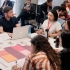 Personas reunidas en mesas de trabajo