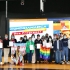 Personas en tarima con la bandera LGBTI