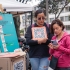 Ciudadana con su celular escaneando código QR de chatico, junto a servidora de la Secretaría Distrital de Planeación.