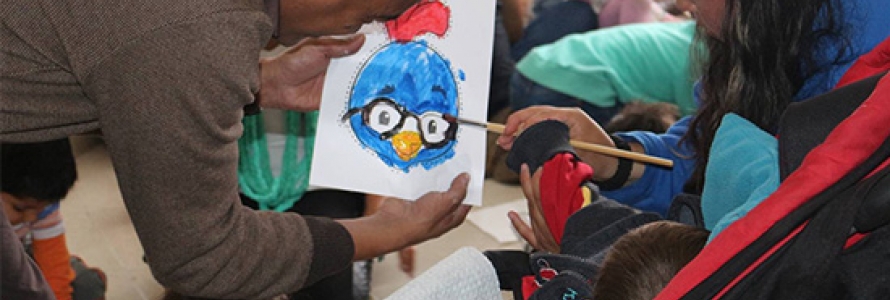Niño pintando un dibujo junto a sus padres