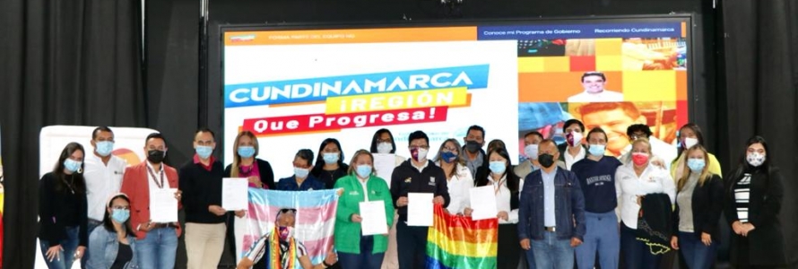 Personas en tarima con la bandera LGBTI