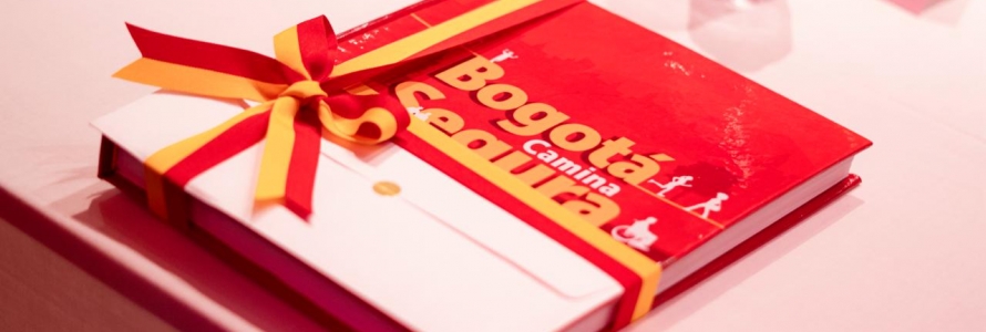 Libro "Bogotá Camina Segura" envuelto en cinta decorativa amarilla y roja.